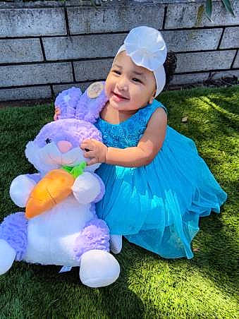 Emily is registered to the contest to win money with this photo: baby, baby_toddler_clothing, child, costume_hat, electric_blue, event, fun, grass, happy, hat, headwear, magenta, mammal, person, pink, purple, recreation, sleeve, smile, stuffed_toy