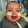 Ander joined the competition — help win amazing prizes! baby, smiling, nasal_cannula, medical_equipment, indoor, child, face, clothing, person, happy, toy, hospital, blue_gloves, closeup, cute, infant, seated, healthcare, background, expression