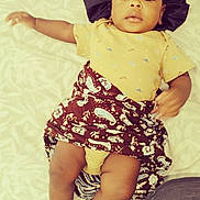 Kayden a rejoint le concours — aidez-le/la à gagner de superbes lots ! baby, bed, blanket, brown, child, clothing, fabric, face, footwear, headwear, laying, legs, pajamas, panda, pattern, person, portrait, socks, textile, yellow