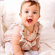 Addie joined the competition — help win amazing prizes! baby, child, smiling, happy, headband, flower, dress, pink, white, blanket, soft, cute, sitting, indoors, portrait, infant, clothing, person, toddler, closeup
