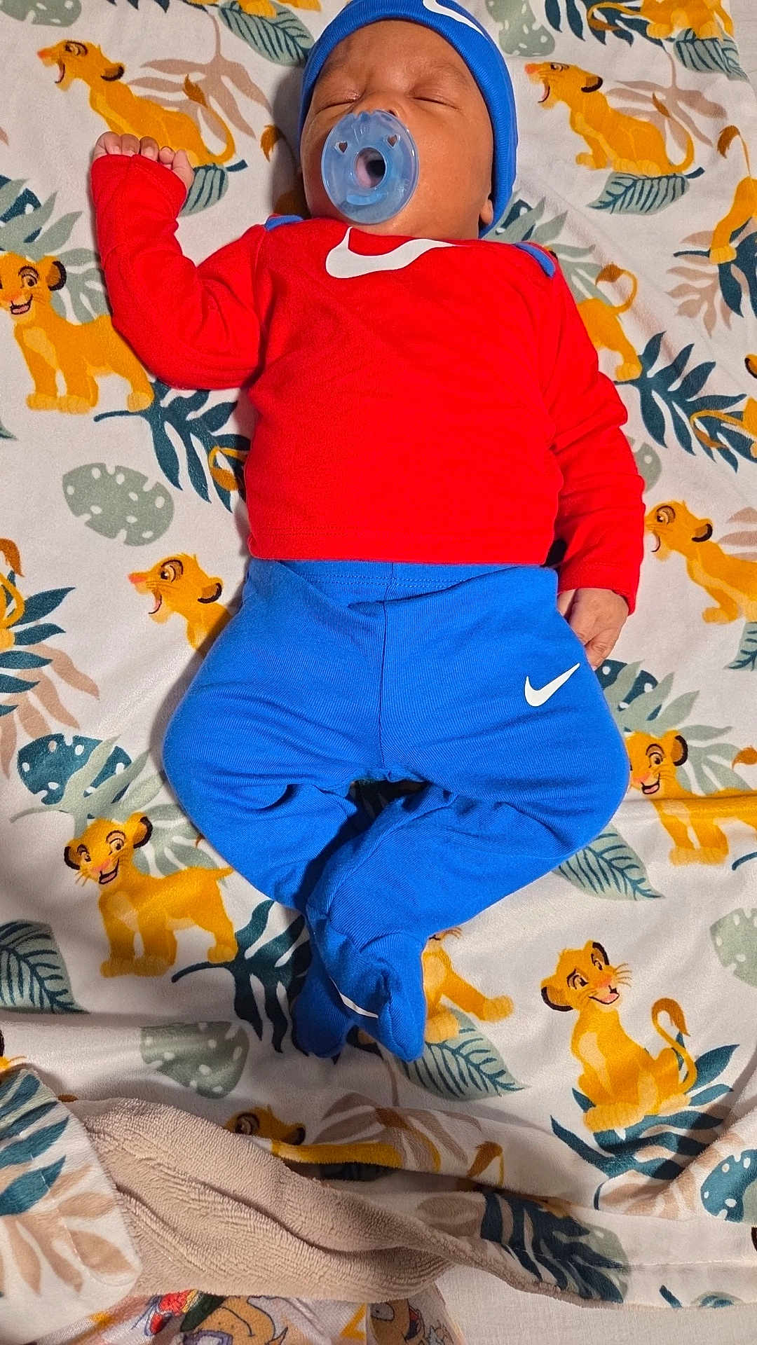 Ky'Mir is registered to the contest to win money with this photo: baby, sleeping, pacifier, hat, red_clothing, blue_clothing, nike, blanket, lion_king, cartoon, pattern, infant, cute, bedtime, child, footed_pants, cozy, indoor, resting, toddler