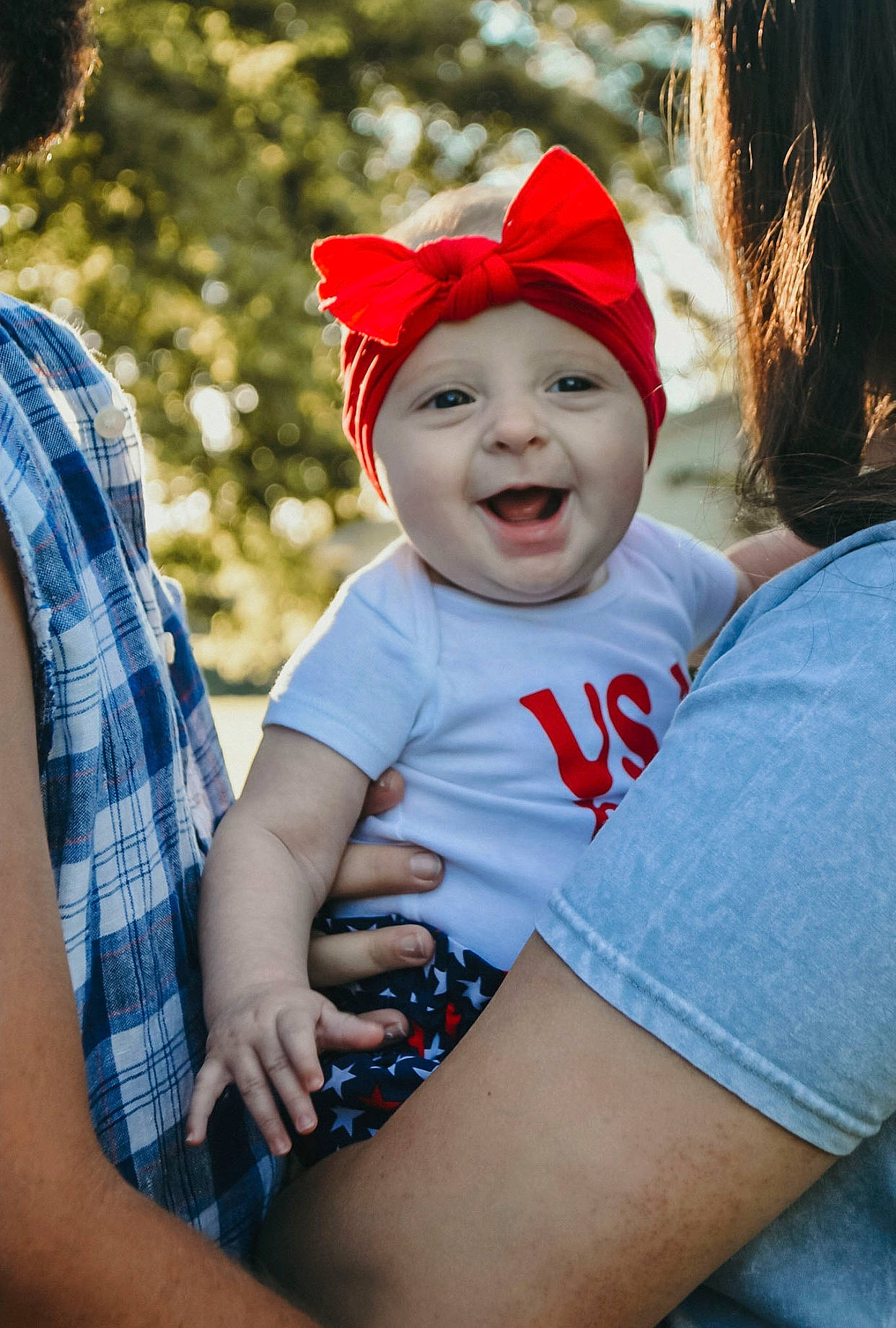 Briana is registered to the contest to win money with this photo: baby, blue, cap, cool, eye, face, fun, grass, happy, hat, headwear, human_body, interaction, iris, leisure, people_in_nature, person, plant, red, skin