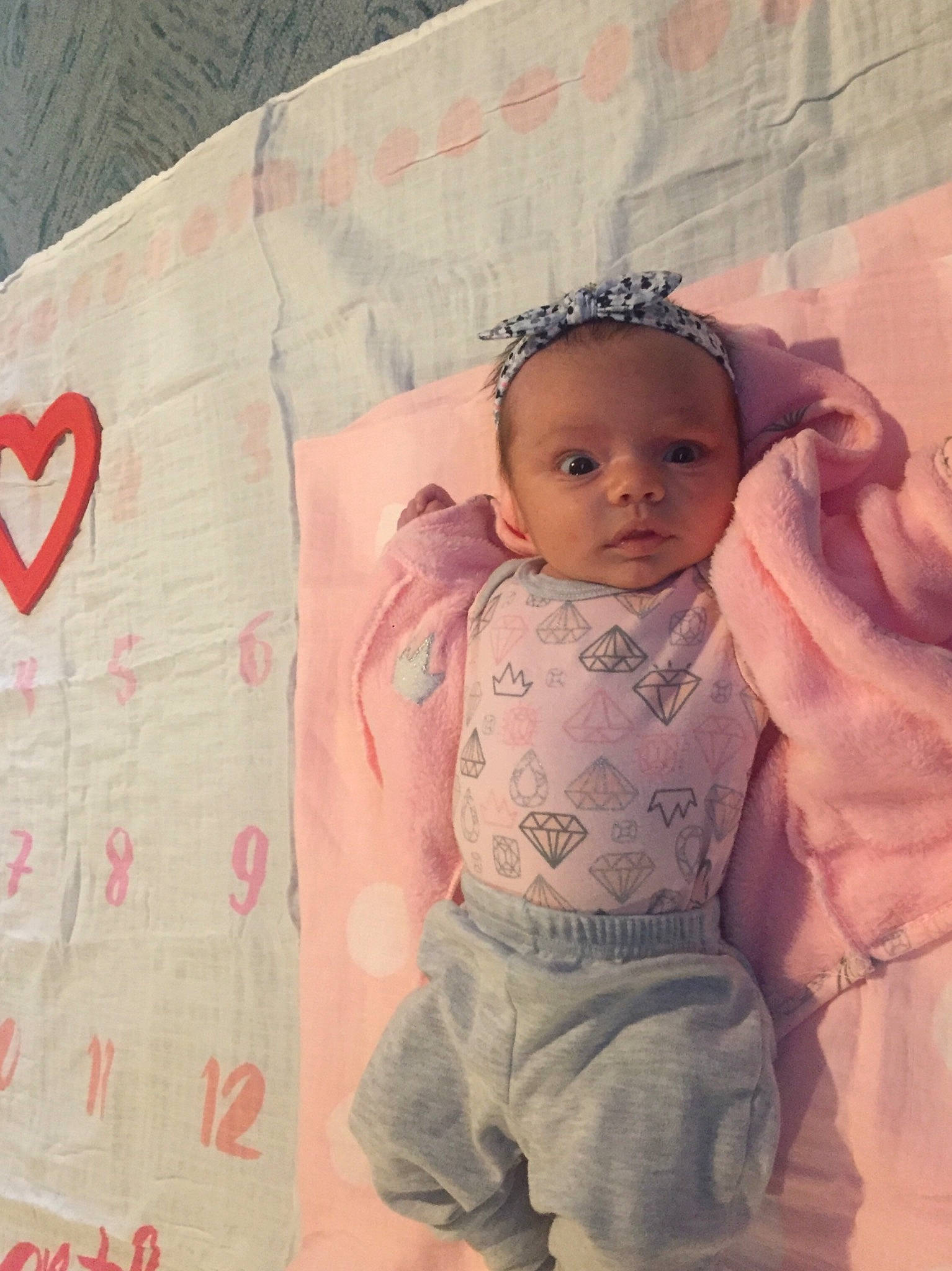 Leyla is registered to the contest to win money with this photo: arm, cheek, child, cool, day, eye, girl, hair_accessory, head, infant, pattern, person, pink, product, skin, textile, toddler