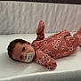 baby, pacifier, crib, mattress, floral_onesie, infant, sleepwear, face, person, lying_down, indoor, head, cute, newborn, soft, resting, child, bed, wall, texture