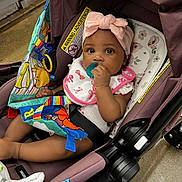Zariyah joined the competition — help win amazing prizes! baby, infant, stroller, headband, pacifier, toy, colorful, child, sitting, clothing, pink, fabric, seatbelt, indoor, floor, blanket, cute, face, expression, person