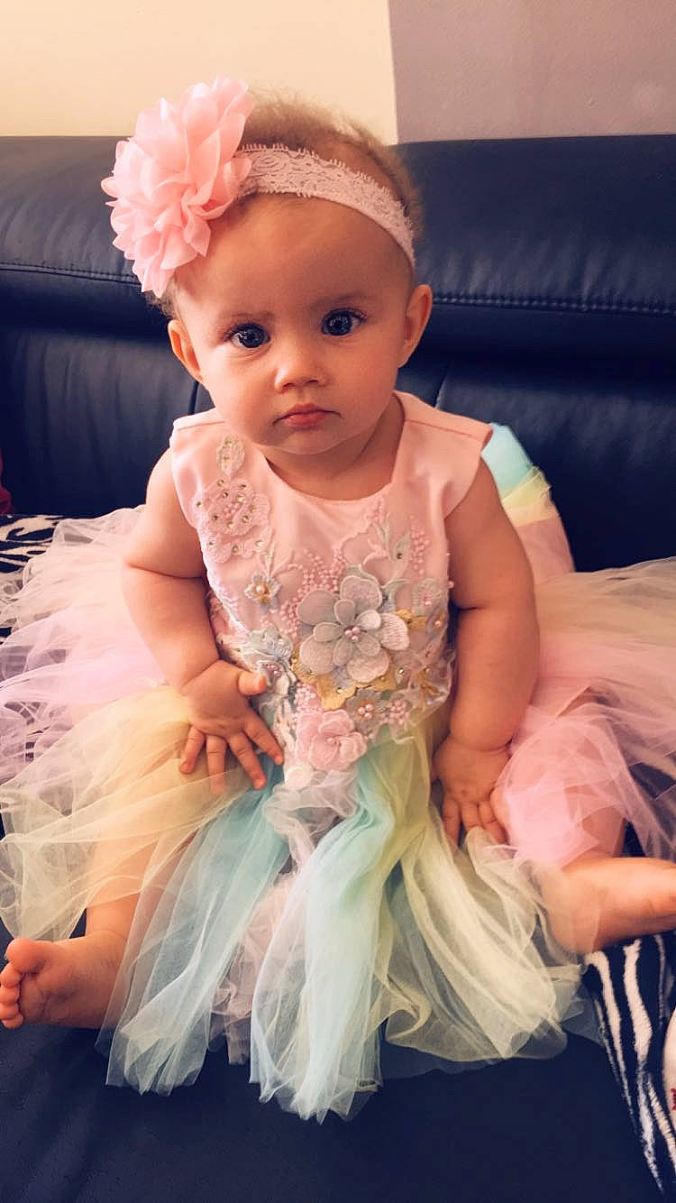 Lauriana participe au concours pour gagner de l'argent avec cette photo : baby, baby_toddler_clothing, bridal_accessory, child, dress, embellishment, event, hair_accessory, happy, headband, headgear, headpiece, iris, jewellery, necklace, person, pink, ruffle, textile, toddler