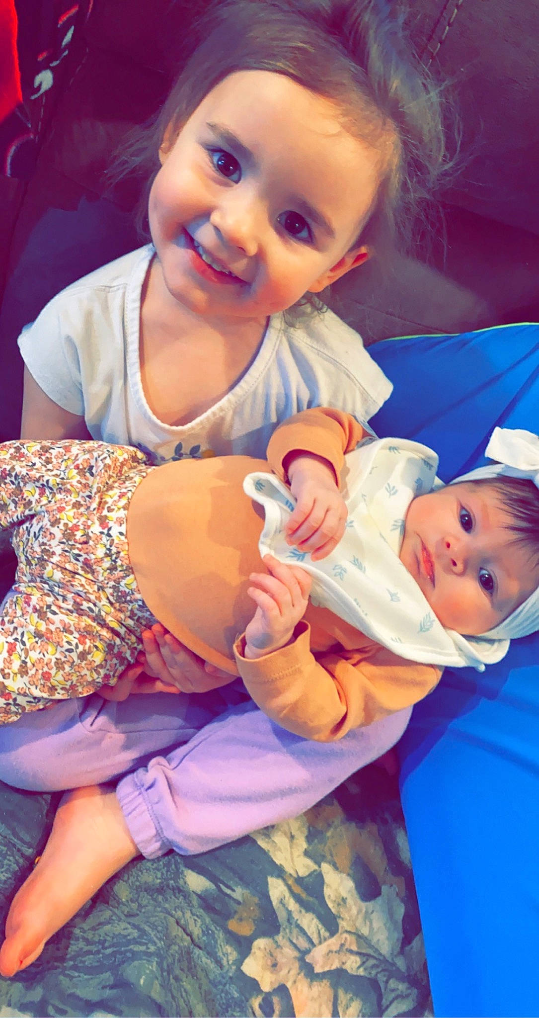 Hadley is registered to the contest to win money with this photo: arm, baby, baby_toddler_clothing, blue, cheek, eye, face, facial_expression, finger, gesture, happy, head, human, human_body, joy, mouth, orange, organ, person, skin