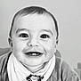 baby, smiling, portrait, close_up, child, teeth, bib, clothing, face, happy, infant, cute, monochrome, eyes, mouth, head, young_child, expression, sitting, indoor