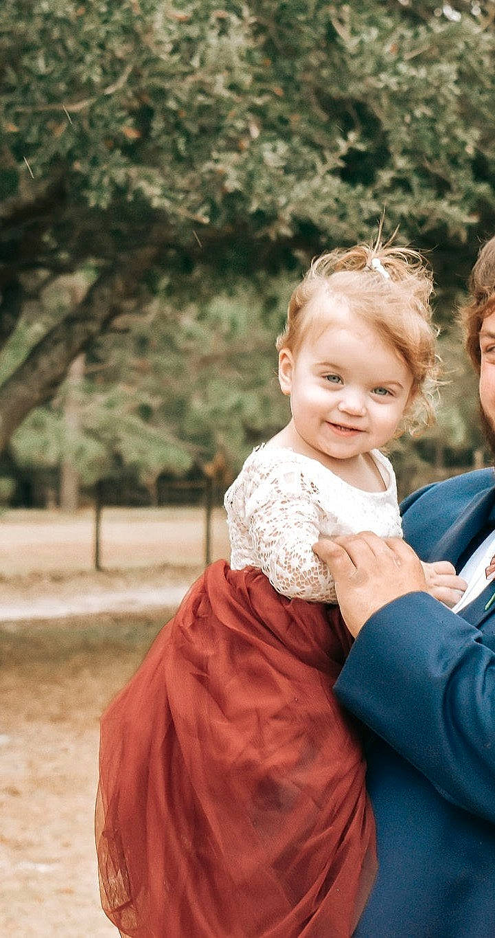 Kendell is registered to the contest to win money with this photo: baby, blond, bridal_clothing, child, clothing, dress, event, flash_photography, formal_wear, fun, gesture, gown, grass, happy, joy, people_in_nature, person, sitting, skin, smile