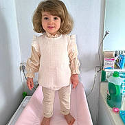 Kamylia a rejoint le concours — aidez-le/la à gagner de superbes lots ! child, toddler, standing, indoor, clothing, sweater, pants, barefoot, changing_table, mirror, bathroom, household_items, plastic_bottle, pacifier, face, hair, smile, person, wall, floor