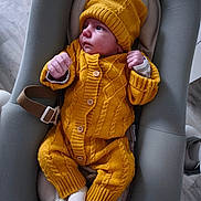 Mylo participe au concours pour gagner de l'argent avec cette photo : baby, infant, knitwear, yellow_clothing, hat, pacifier, baby_seat, white_socks, floor, wooden_floor, indoor, cute, child, portrait, person, newborn, cozy, warm_clothing, resting, looking_away