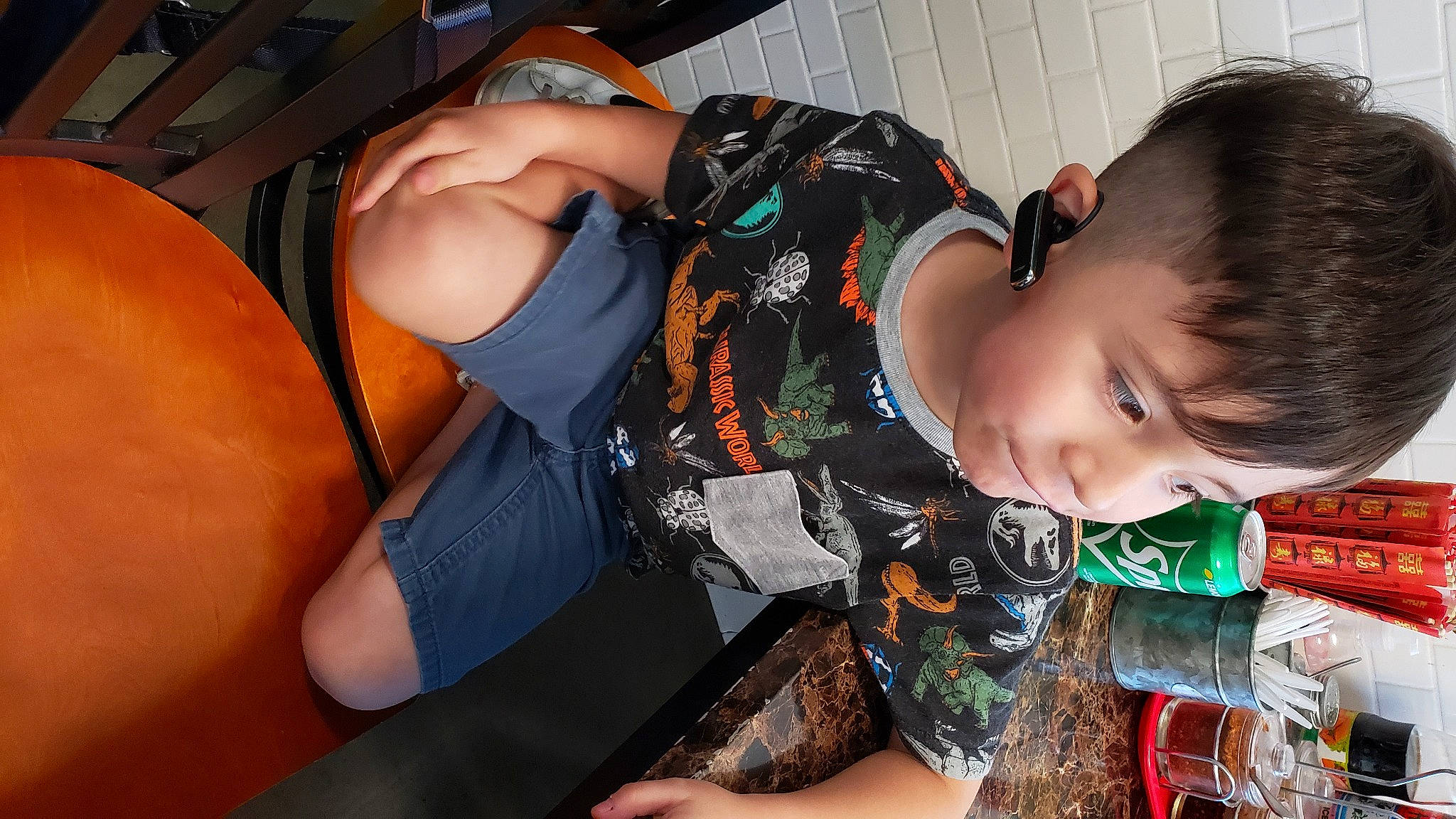Jayden is registered to the contest to win money with this photo: baby, black_hair, child, elbow, eyewear, fun, happy, human_leg, pattern, person, personal_protective_equipment, plaid, sitting, thigh, toddler