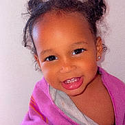 Awa participe au concours pour gagner de l'argent avec cette photo : toddler, child, smile, face, hair_buns, blanket, purple, happy, cute, indoors, portrait, young_child, person, skin, head, eyes, earrings, teeth, warm, cozy