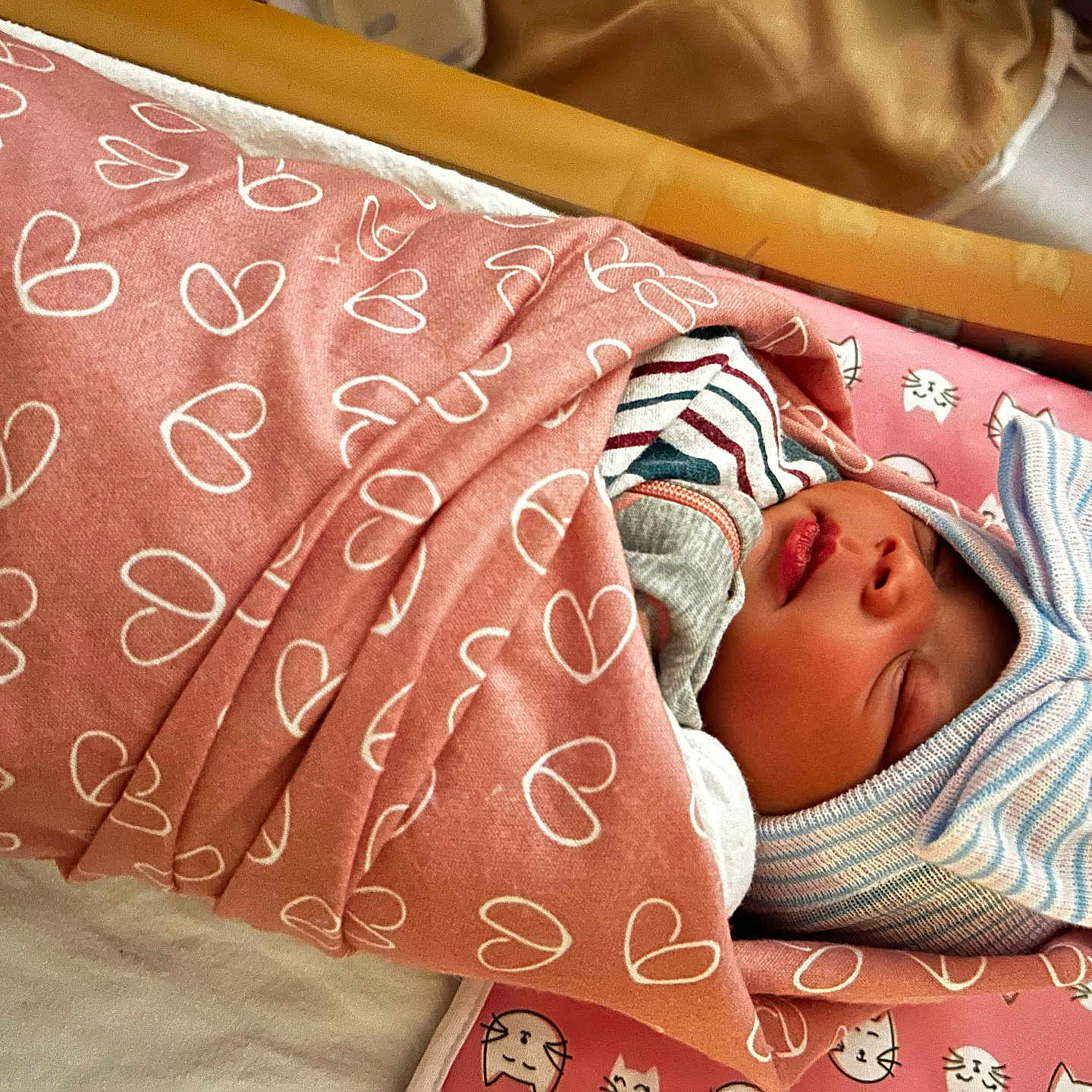 Layauna is registered to the contest to win money with this photo: baby, bed, blanket, bow, cat_faces, cozy, cute, hat, hearts, indoors, infant, mat, newborn, person, pink, portrait, sleeping, soft_lighting, striped, wrapped