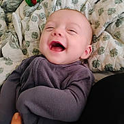Cylis is registered to the contest to win money with this photo: baby, laughing, pajamas, blanket, pacifier, infant, smile, child, cute, happy, person, portrait, indoors, cozy, sleepwear, head, face, hand, fabric, comfort