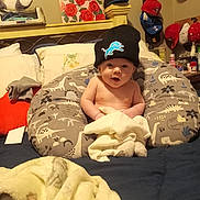 Cylis joined the competition — help win amazing prizes! baby, infant, beanie, hat, pillow, bed, blanket, dinosaur_pattern, room, caps, valentines_day_card, stuffed_animal, toys, clothing, face, child, indoor, person, cozy, home