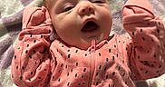Elena is registered to the contest to win money with this photo: baby, infant, child, portrait, lying_down, pink_outfit, polka_dots, blanket, bed, face, eyes, open_mouth, yawning, indoor, cozy, close_up, baby_clothing, zipper, head, adorable