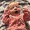baby, infant, child, portrait, lying_down, pink_outfit, polka_dots, blanket, bed, face, eyes, open_mouth, yawning, indoor, cozy, close_up, baby_clothing, zipper, head, adorable