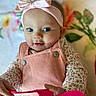 Remi is registered to the contest to win money with this photo: baby, baby_toddler_clothing, cheek, child, doll, dress, eye, eyelash, fawn, happy, head, iris, jewellery, lip, necklace, pattern, peach, pink, skin, toy
