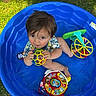toddler, child, blue_pool, toy_ball, colorful_toys, grass, outdoor, playing, summer, plastic_pool, curious, looking_up, short_hair, casual_clothing, daylight, barefoot, happy, fun, baby, playtime