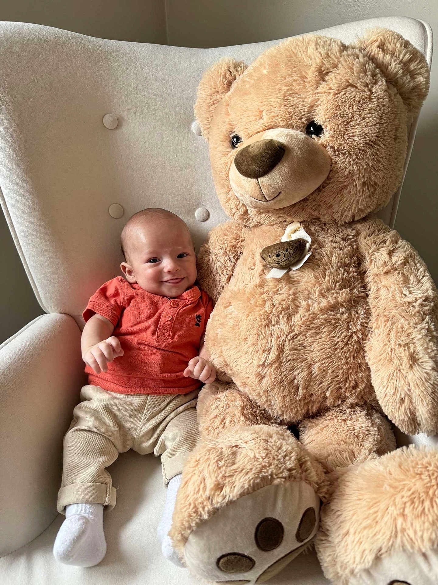 Marius a rejoint le concours — aidez-le/la à gagner de superbes lots ! baby, infant, teddy_bear, plush_toy, armchair, smiling, child, cozy, indoor, soft_toy, cute, happy, furniture, comfort, childhood, portrait, casual_clothing, socks, relaxed, home