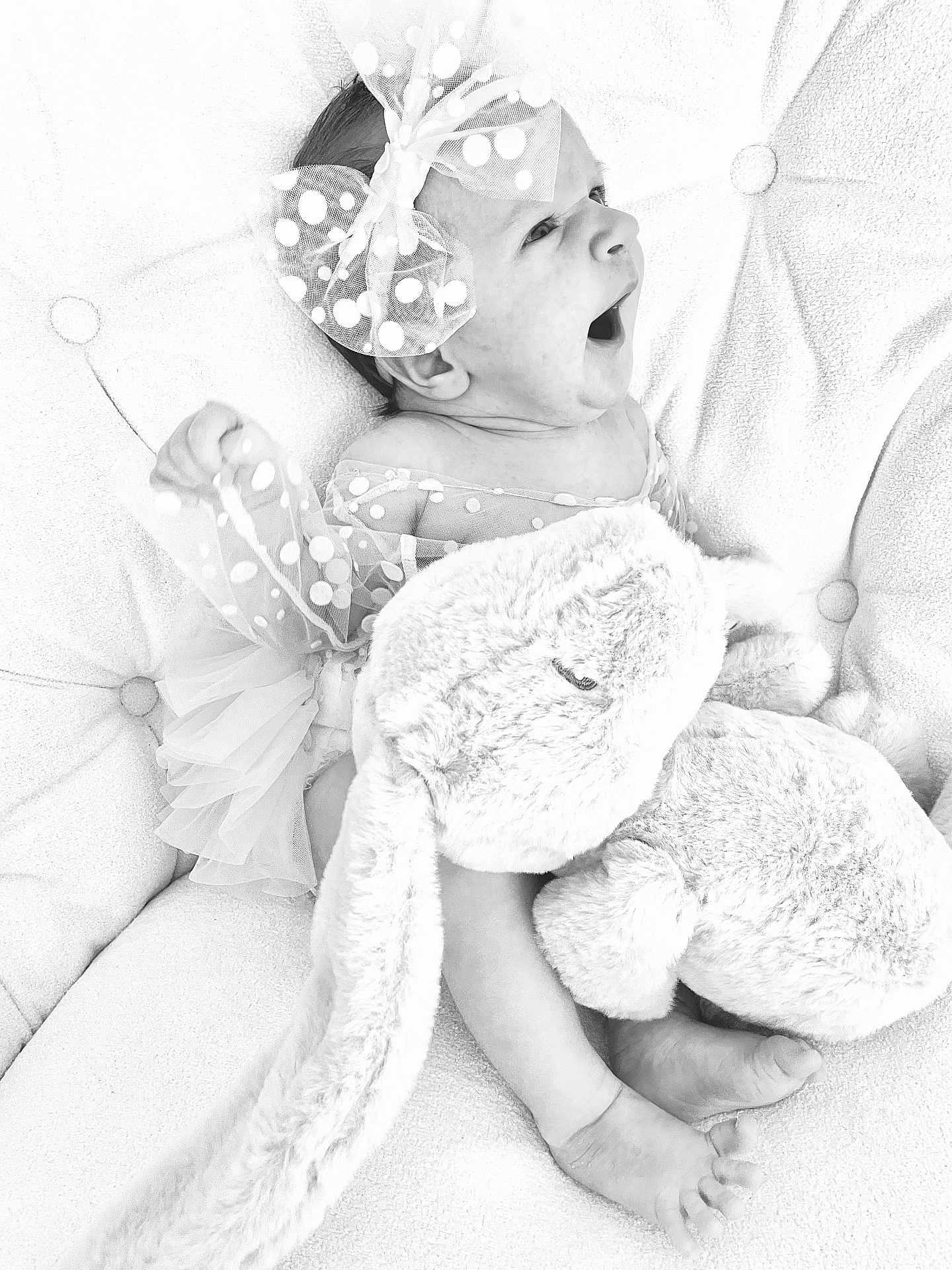 Victoria participe au concours pour gagner de l'argent avec cette photo : baby, infant, polka_dot, bow, stuffed_animal, plush_toy, tufted_cushion, yawning, black_and_white, cute, sleepy, soft_texture, child, adorable, resting, clothing, foot, hand, portrait, indoor