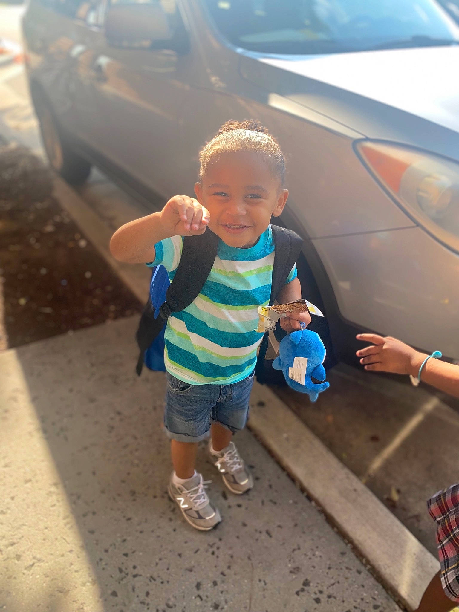 Ashton is registered to the contest to win money with this photo: asphalt, automotive_design, automotive_exterior, automotive_lighting, automotive_tire, bumper, car, cool, hood, joy, land_vehicle, motor_vehicle, person, personal_luxury_car, public_space, road, shorts, tire, toddler, trunk