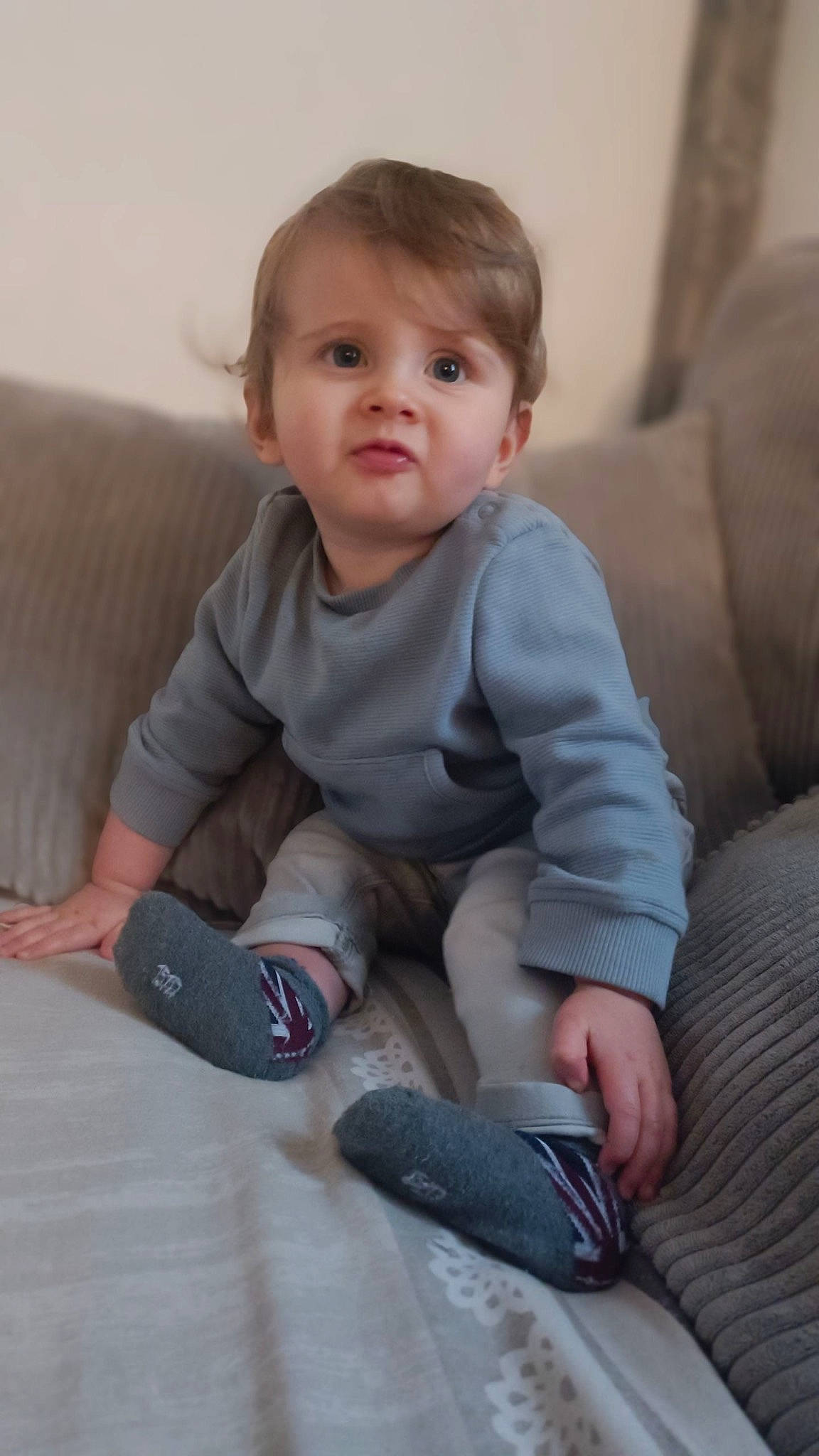 Aïden a rejoint le concours — aidez-le/la à gagner de superbes lots ! baby, baby_toddler_clothing, cheek, child, comfort, elbow, facial_expression, flooring, human_leg, joint, knee, leg, person, sitting, skin, sleeve, sock, standing, thigh, toddler