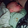 River is registered to the contest to win money with this photo: baby, sleeping, blanket, pajamas, tattoo, arm, closeup, cozy, indoor, child, person, face, peaceful, resting, soft, comfort, cuddle, bed, cute, infant