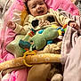 baby, smiling, infant, plush_toys, blanket, baby_seat, pink, clothing, happy, indoor, face, child, soft_toys, cute, comfort, person, portrait, sitting, cozy, home