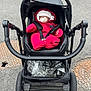 baby, stroller, pacifier, red_snowsuit, hat, sleeping, infant, outdoor, asphalt, wheels, black_stroller, child, winter_clothing, bundle, peaceful, cute, urban, transport, seat, baby_gear