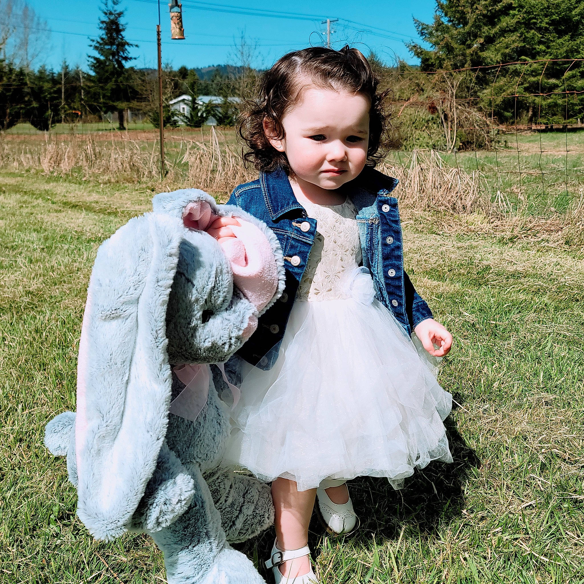 Maisie is registered to the contest to win money with this photo: baby, baby_toddler_clothing, dress, fun, fur, grass, grassland, happy, meadow, pattern, people_in_nature, person, plant, prairie, sitting, sky, sleeve, spring, textile, toddler