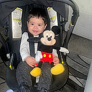 Mateo is registered to the contest to win money with this photo: boy, child, clothing, face, footwear, head, helmet, homedecor, male, pants, person, photography, portrait, shoe, sitting, sneaker, stroller, toy, transportation, vehicle