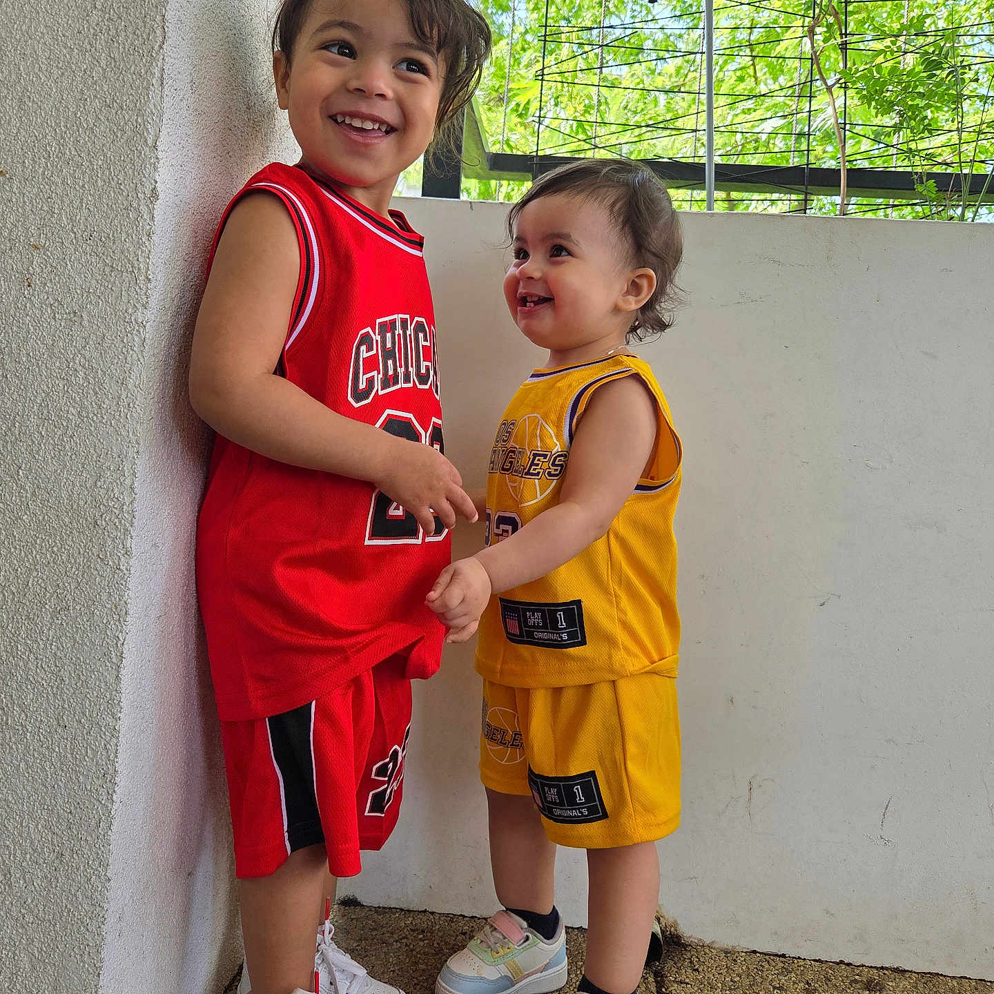 Tamra participe au concours pour gagner de l'argent avec cette photo : basketball_jersey, casual, child, children, cute, daylight, friendship, greenery, happy, laughing, outdoor, playful, portrait, smiling, sneakers, sportswear, standing, toddler, two_children, wall