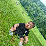Tamra a rejoint le concours — aidez-le/la à gagner de superbes lots ! baby, black_clothing, casual, child, cute, daylight, fun, grass, greenery, infant, nature, outdoor, park, people, relaxation, scenery, sitting, smile, trees, young