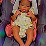 baby, child, infant, car_seat, floral_dress, headband, pink_flower, pacifier, legs, feet, indoors, person, cute, skin, face, seated, clothing, soft_toys, safety, evenflo