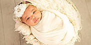 Kru joined the competition — help win amazing prizes! baby, infant, wrapped, blanket, headband, flower, basket, fur, soft_texture, wooden_floor, indoors, portrait, cute, newborn, resting, peaceful, closeup, warm_lighting, comfortable, adorable