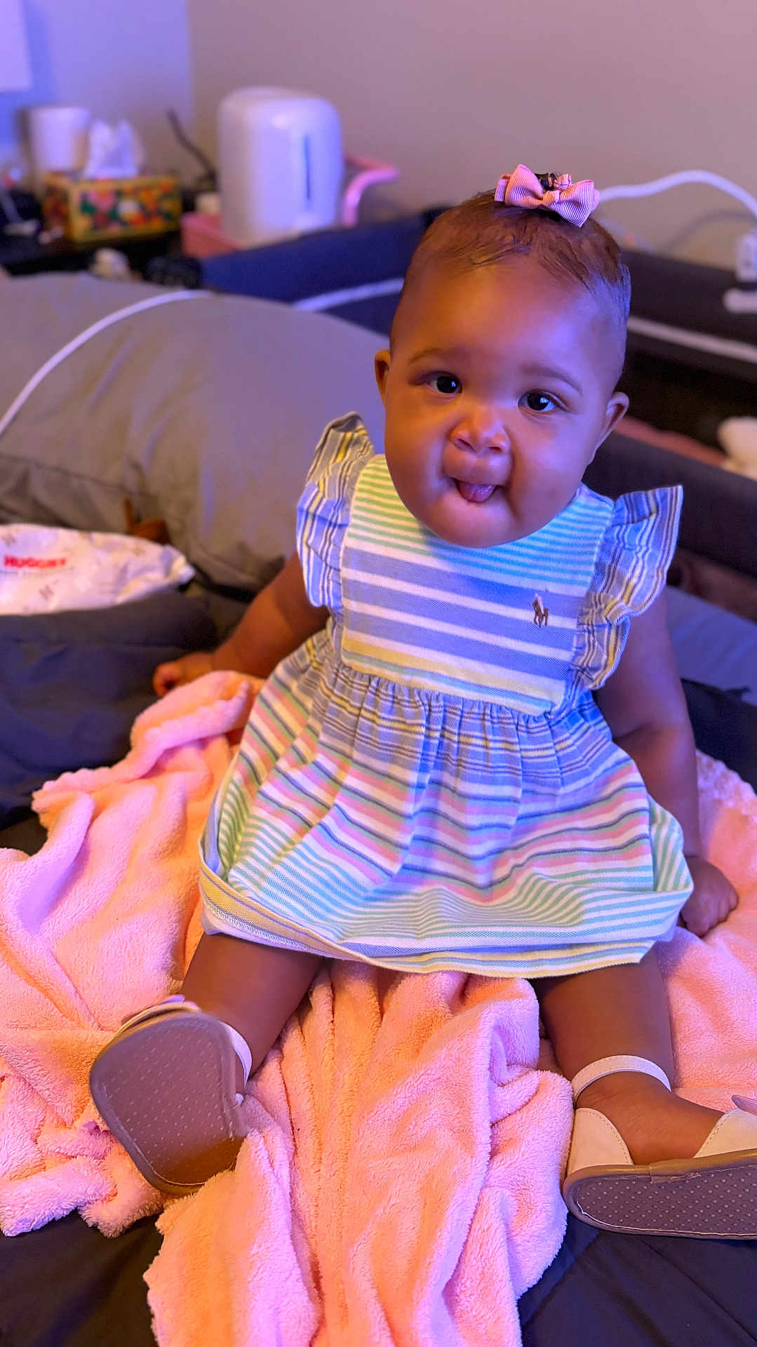 Kru joined the competition — help win amazing prizes! baby, child, infant, dress, bow, blanket, pink, smiling, tongue_out, sitting, footwear, indoor, bed, pillow, soft, cute, person, young, happy, cozy