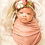 newborn, baby, swaddled, blanket, flower_headband, floral, portrait, soft_texture, infant, cute, wrapped, peaceful, white_background, flower_petals, closeup, adorable, headband, baby_face, soft_lighting, cozy