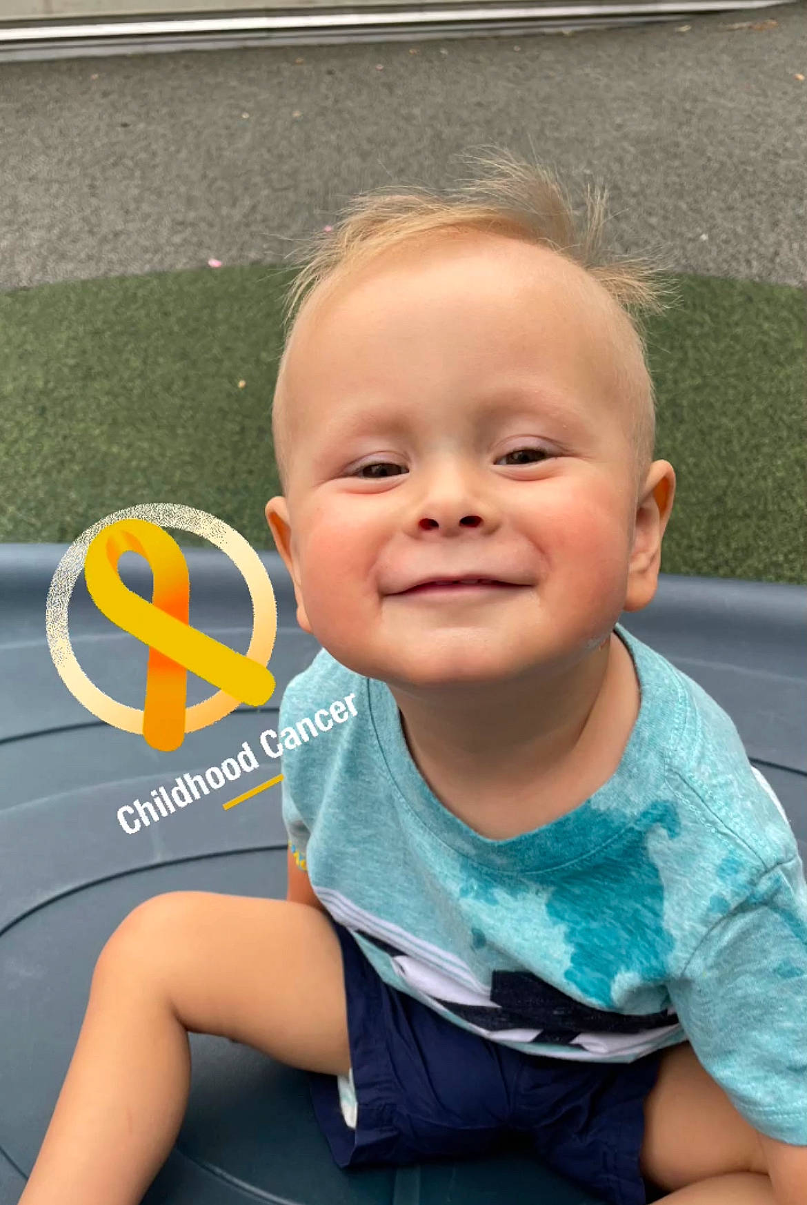 Jackson is registered to the contest to win money with this photo: asphalt, auto_part, baby, baby_products, baby_toddler_clothing, child, fun, grass, happy, joy, leisure, logo, person, recreation, road, sitting, skin, smile, t_shirt, toddler