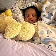 Jahyeir is registered to the contest to win money with this photo: baby, sleeping, blanket, stuffed_animal, plush, bed, cozy, child, infant, soft_toys, comfort, cute, rest, portrait, face, indoor, warm, peaceful, nursery, sleep