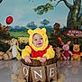 baby, costume, winnie_the_pooh, bucket, birthday, plush_toys, hundred_acre_wood, decorations, sign, smile, child, yellow, red, floor, background, balloon, tree, signage, celebration, cute