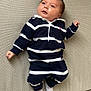 baby, child, couch, cozy, expression, face, feet, hands, head, indoor, infant, looking_up, lying_down, navy_stripes, onesie, portrait, socks, striped_clothing, upholstery, white_stripes