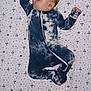 baby, sleeping, onesie, tie_dye, bed, sheet, space_pattern, stars, planets, rocket, infant, child, peaceful, cute, pajamas, sleepwear, portrait, rest, indoors, blanket