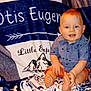 baby, child, smiling, blue_eyes, ginger_hair, shirt, shorts, barefoot, blanket, mountain_design, text, indoor, cute, happy, sitting, portrait, cozy, toddler, clothing, person