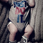 Otis is registered to the contest to win money with this photo: baby, infant, onesie, textile, sneakers, socks, blanket, laying_down, face, expressionless, clothing, footwear, child, person, cute, indoor, soft_texture, motivation, slogan, young