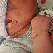 Xavier is registered to the contest to win money with this photo: newborn, baby, sleeping, infant, cap, blanket, hospital_bracelet, clothing, skin, hand, face, ear, wrinkle, soft, closeup, peaceful, resting, cute, indoors, toddler