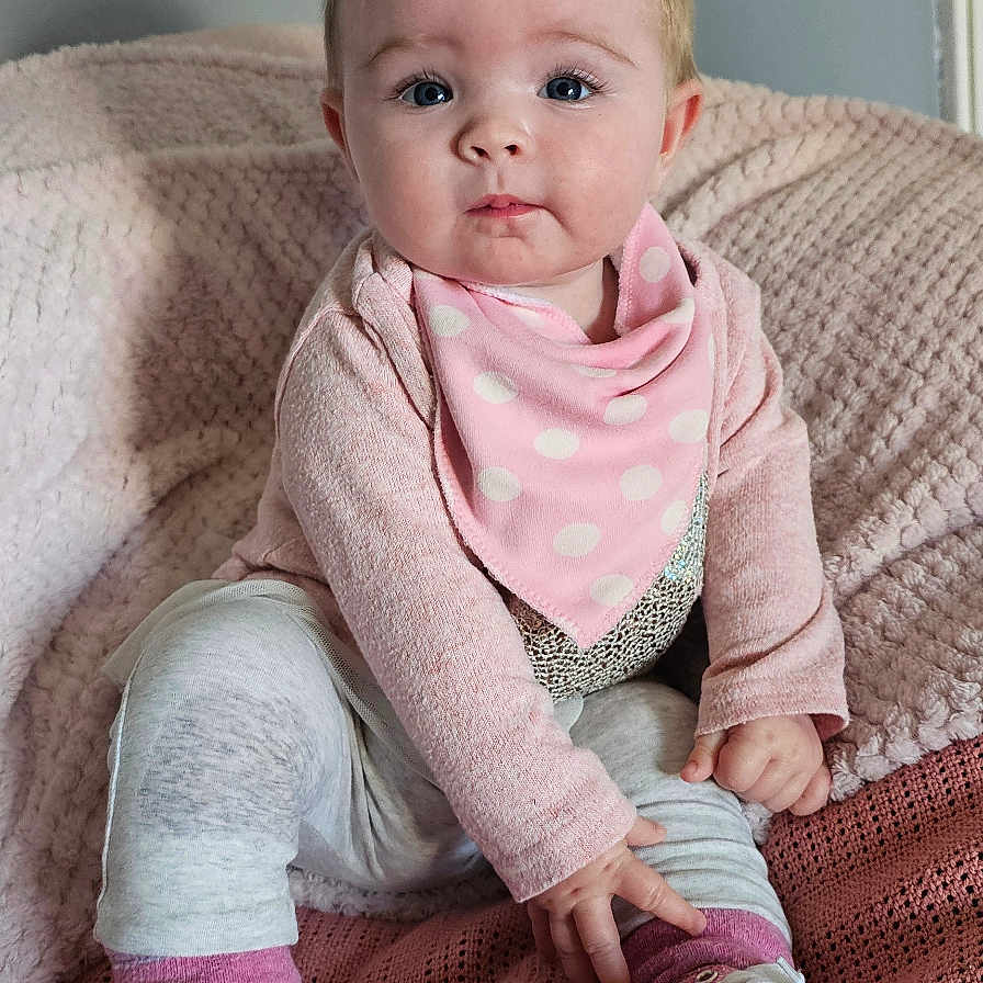 Freja is registered to the contest to win money with this photo: baby, bodypart, clothing, couch, face, finger, footwear, furniture, hand, happy, head, knitwear, pants, person, photography, portrait, shoe, sitting, sneaker, sweater