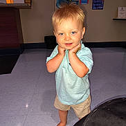 Hank is registered to the contest to win money with this photo: toddler, child, barefoot, blue_eyes, blonde_hair, shorts, polo_shirt, indoor, floor, tile_floor, posing, smiling, hands_on_face, cute, person, portrait, casual_clothing, background, cutout, photography