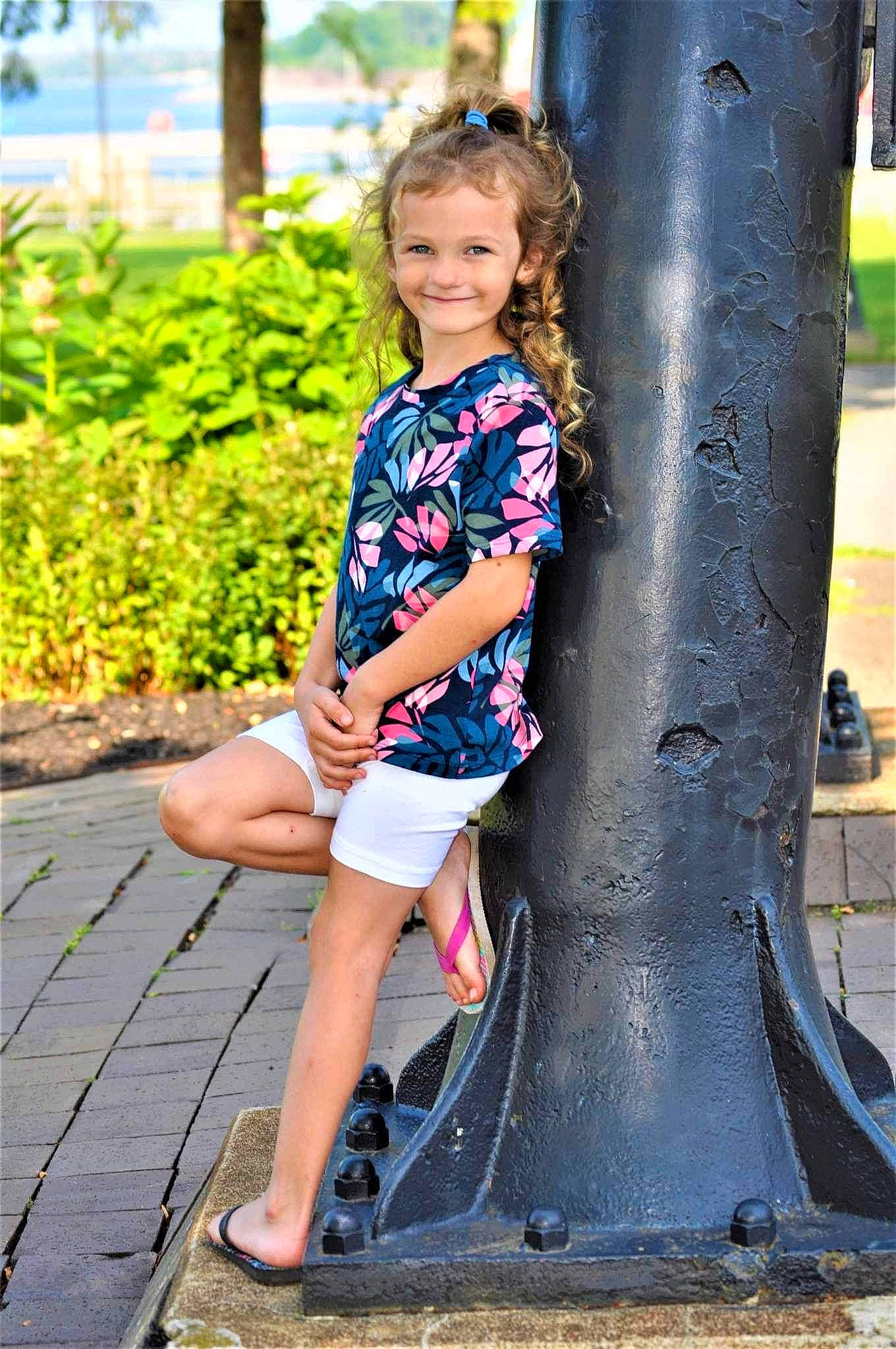 Genevieve is registered to the contest to win money with this photo: child, electric_blue, eye, fun, grass, happy, human_body, human_leg, joy, leg, leisure, people_in_nature, person, plant, recreation, shoe, thigh, toddler, tree, trunk